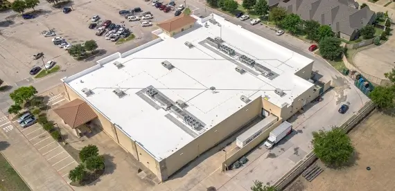 Aerial view of a commercial building with a new roof.